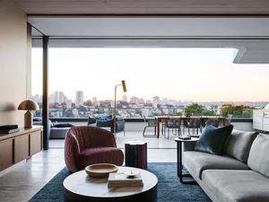 Modern living room with city view, featuring comfortable seating and a stylish coffee table.