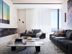A modern living room with a marble coffee table and minimalist furniture.