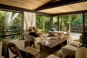 A modern living room with wood floors, furniture, and accents