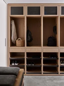 Modern wooden lockers with wicker basket and woven rug hanging.