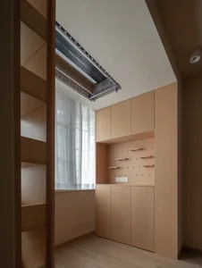 Modern minimalist closet with wooden shelves and cabinets.