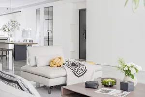A modern minimalist living room with white leather furniture.