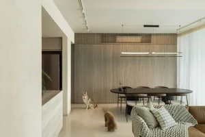 A modern residential interior with a wooden table, concrete floor, and metal chairs.