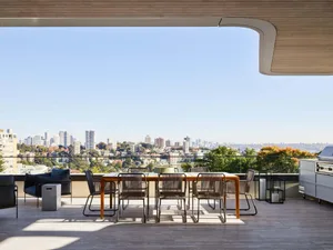 Outdoor dining area with modern furniture and panoramic city view.
