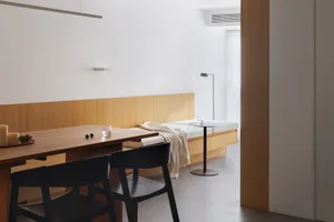 A minimalist residential interior featuring wood, glass, and concrete elements.