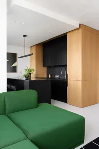 Modern green sofa with white upholstery in a room with a white floor.