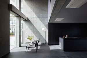 A minimalist residential interior featuring concrete walls and a clean, modern aesthetic.
