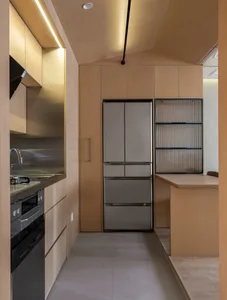 Modern residential kitchen featuring minimalist design with wood finishes and sleek stainless steel appliances.
