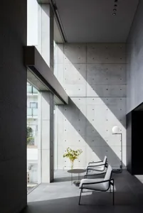 Modern living room featuring minimalist design with concrete walls and floor.