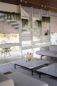 Minimalist living room featuring concrete walls and glass furniture.