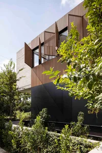 A modern residential exterior featuring wooden panels and large windows.