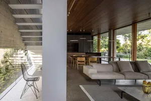 Modern residential interior featuring concrete, glass, and wood materials.