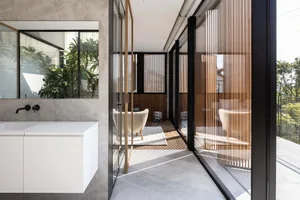 A modern bathroom featuring concrete and glass materials.