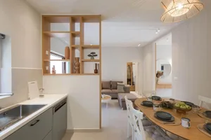 Modern minimalist kitchen dining and living room featuring wooden materials and furniture.