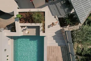 A minimalist residential pool with concrete finishes and stone accents.