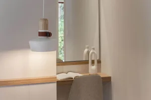 A well-lit, modern desk space featuring a white pendant lamp and a wooden frame.
