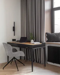 A modern minimalist home office featuring a wooden desk and fabric chair, with gray curtains and a window.