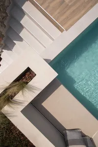 Modern outdoor swimming pool with concrete deck and steps.