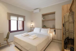 A minimalist bedroom featuring textured walls and a comfortable bed.