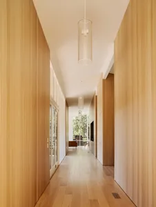 A modern corridor with wooden walls and floor, featuring minimalist design.