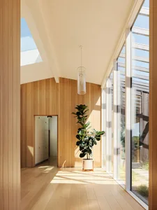 Modern hallway with wooden walls and glass doors.