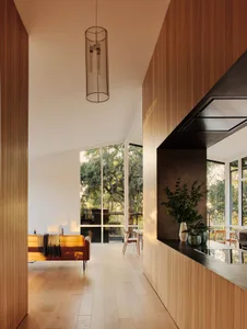 A minimalist living room with wood laminate flooring, a yellow sofa, and large windows.