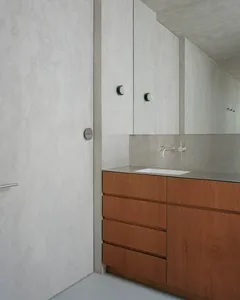 A modern bathroom with concrete walls and minimalist design elements.