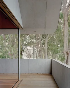 Modern residential architecture featuring concrete walls and wooden flooring.