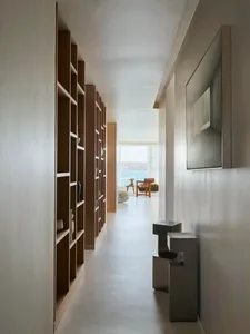 簡約住宅走廊，牆面設有木質層架。