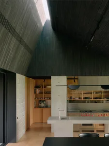The interior design showcases minimalist architecture with concrete finishes and modern fixtures.