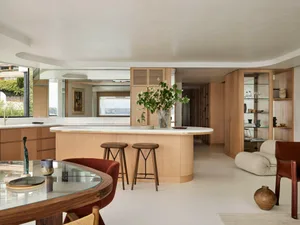 An elegant modern apartment interior featuring a living room with a white marble floor, wooden furniture, and a large kitchen