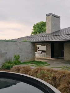 A modern residential exterior featuring concrete and metal materials with a glass window.