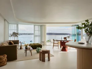 Modern living room with panoramic ocean view, featuring minimalist furniture and contemporary decor elements.