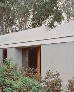 Modern residential building with a white, corrugated metal exterior.