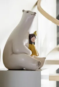 A large white bear sculpture with a small girl sleeping on its back.