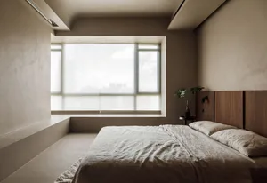 A minimalist bedroom with a concrete floor, bed, and large window.