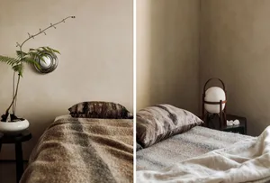 Minimalist bedroom with a cozy wool blanket, leather pillow, and modern lighting fixture.