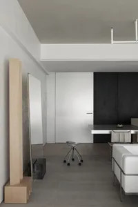 A minimalist living room with concrete surfaces and a modern chair.