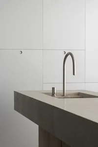 Modern bathroom featuring a concrete vessel sink and sleek faucet.