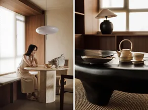 A modern interior space featuring a marble table with a wooden bench and a round pendant light.