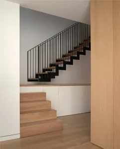 Modern interior staircase with wooden steps and black metal railing