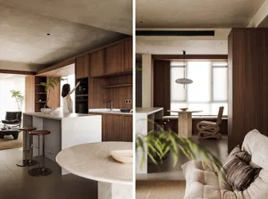 Modern kitchen and living space featuring marble countertops, wooden cabinets, and concrete flooring.