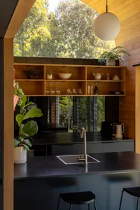 Modernly designed kitchen with open-plan floor layout, featuring dark wooden flooring and modern fixtures.