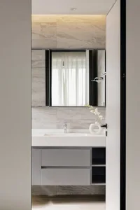 Modern bathroom with marble countertops, glass fixtures, and a minimalist design.