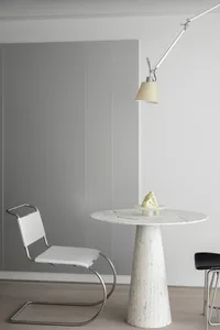 A modern minimalist dining room with a white marble table and matching chairs.