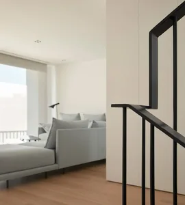 Modern minimalist living room with white walls and a light-colored sofa.