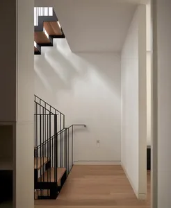 Modern minimalist staircase with wooden steps and metal railings.