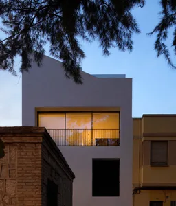 Modern, white, concrete residential building exterior at night