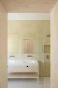 A minimalist bathroom with wood accents and a glass shower enclosure.