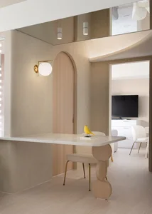 A minimalist residential space featuring neutral tones, wood, marble, and metal elements.